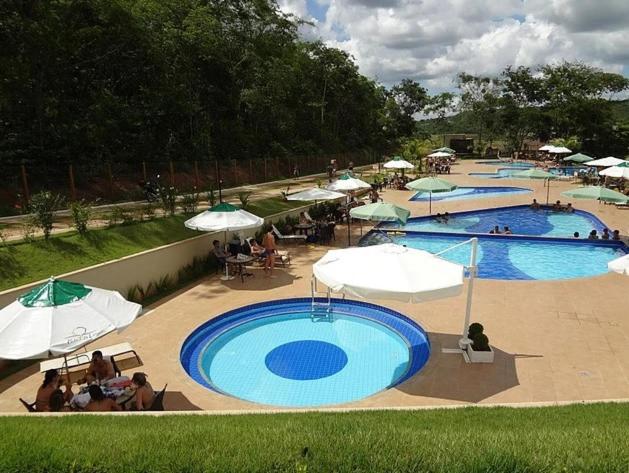 una gran piscina con sombrillas y gente sentada a su alrededor en ALDEIA DO LAGO, en Caldas Novas