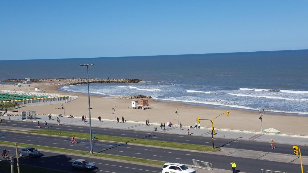 un grupo de personas caminando en una playa junto al océano en Sargento cabral 73 en Mar del Plata