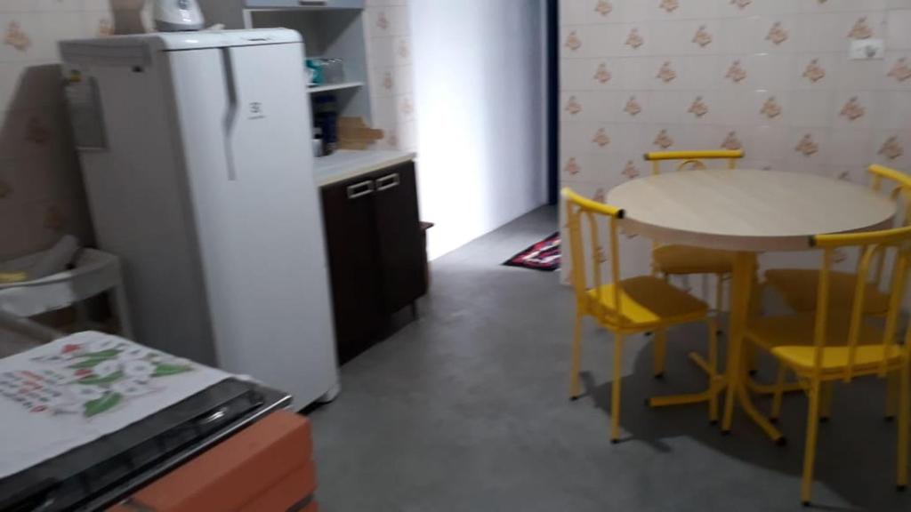 een keuken met een kleine tafel en een koelkast bij Kitnet em Matinhos PR in Matinhos