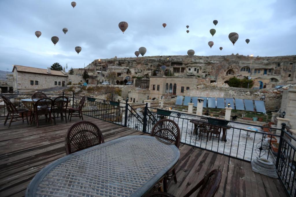 a deck with hot air balloons flying in the sky at Antik Cave House in Urgup