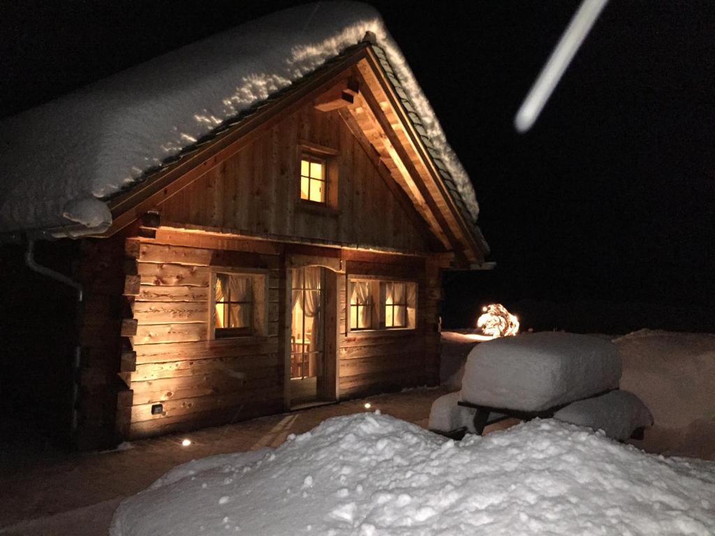 una cabaña de madera en la nieve por la noche en Alpine Chalet, en Santa Caterina Valfurva