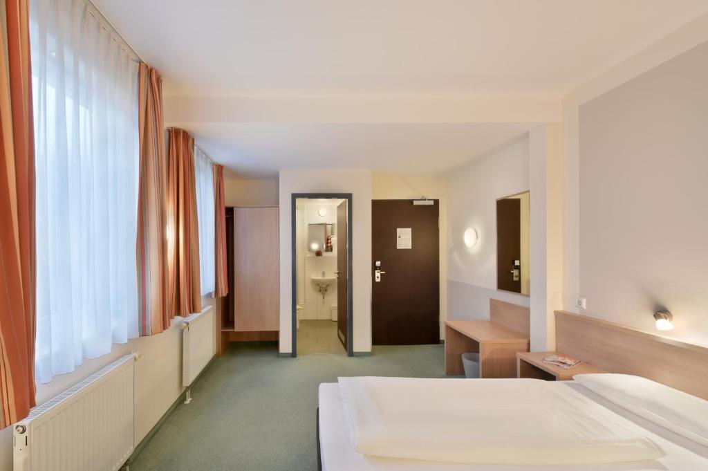 a hotel room with a bed and a corridor at meinHotel in Hamburg