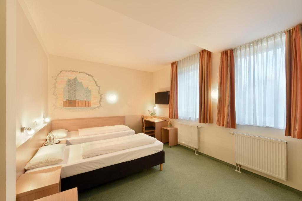a hotel room with two beds and a television at meinHotel in Hamburg