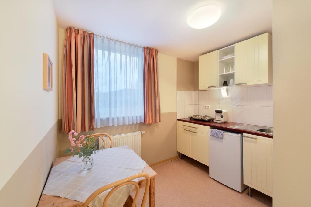 a small kitchen with a table with a vase of flowers on it at meinHotel in Hamburg