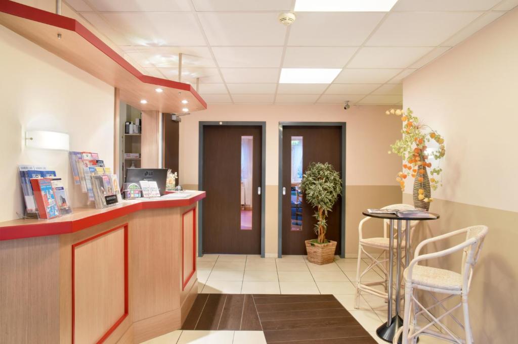 a lobby of a hospital with a counter and chairs at meinHotel in Hamburg