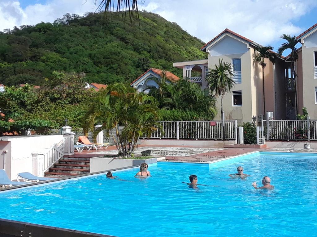 um grupo de pessoas a nadar numa piscina em Residence des salines em Sainte-Anne