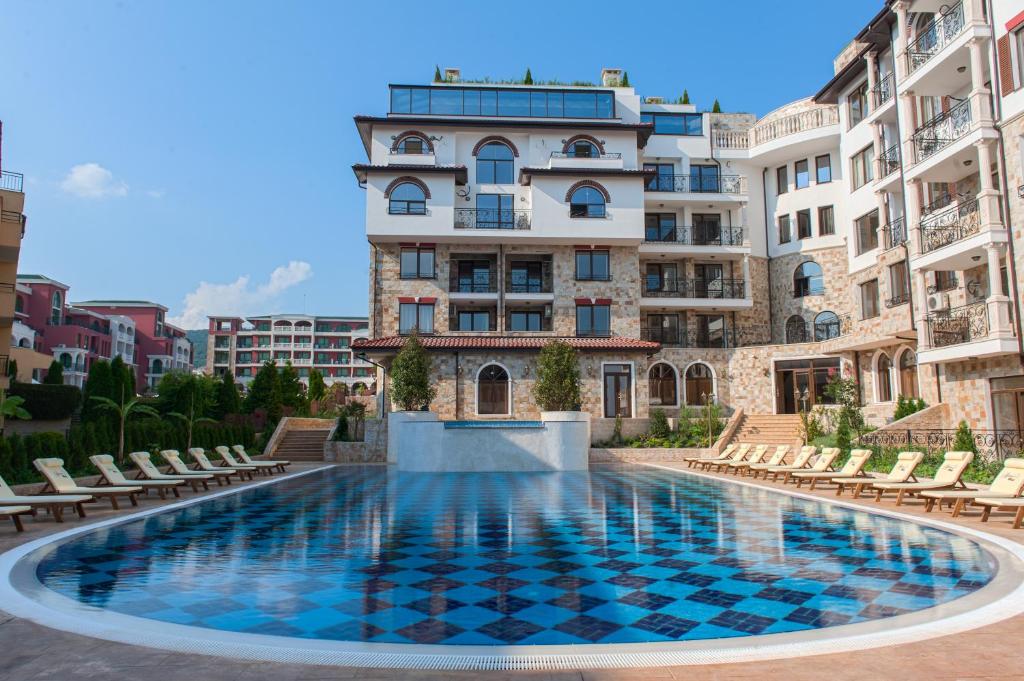 a swimming pool in front of a building at Artur VIP Residence Club in Sveti Vlas