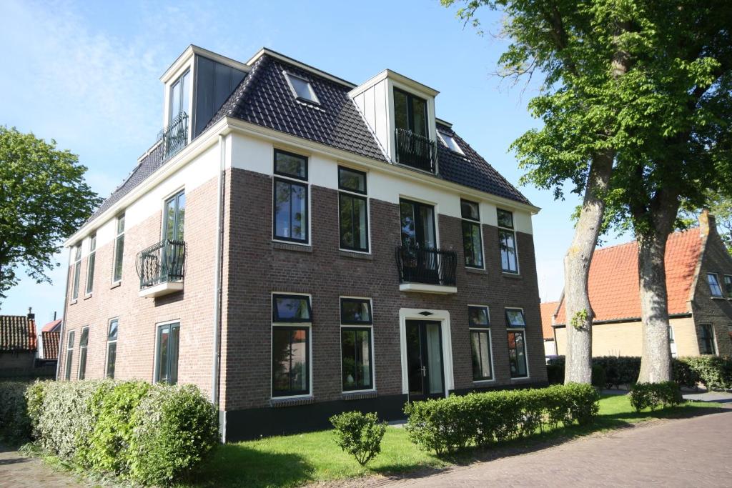 a large brick house with a black roof at Staetige Dames in Nes