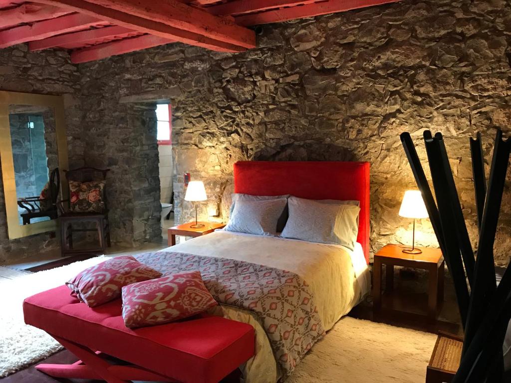 ein Schlafzimmer mit einem Bett und einer Steinmauer in der Unterkunft Quinta das Anoneiras in Calheta