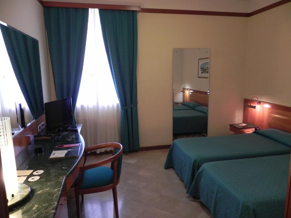 Habitación de hotel con cama y escritorio con ordenador en Hotel Vecchio Mulino, en Monopoli