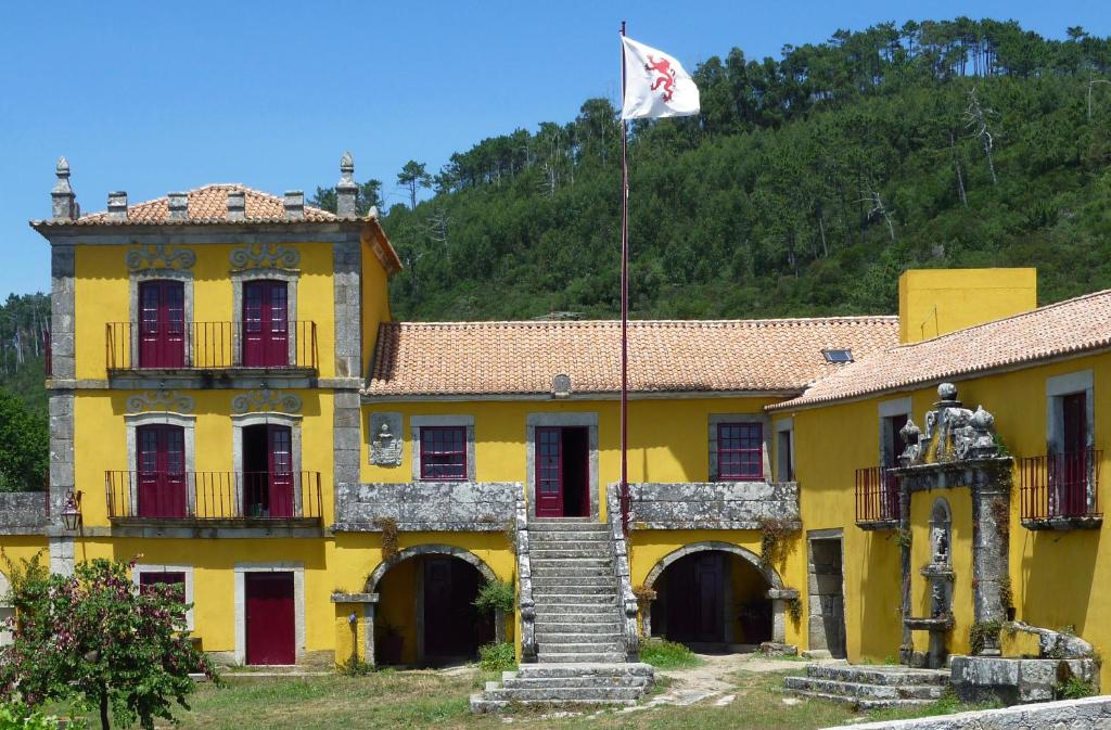um edifício amarelo com uma bandeira em cima em Quinta da Boa Viagem em Viana do Castelo