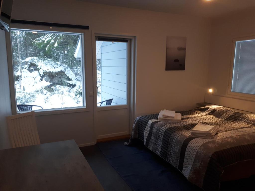 een slaapkamer met een bed en een groot raam bij Vuokatti Slope Suite in Vuokatti