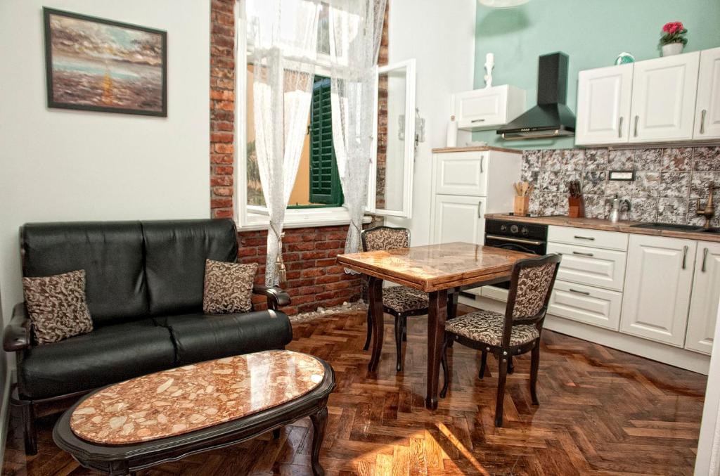 uma sala de estar com um sofá e uma mesa em Apartment Nostalgie em Opatija