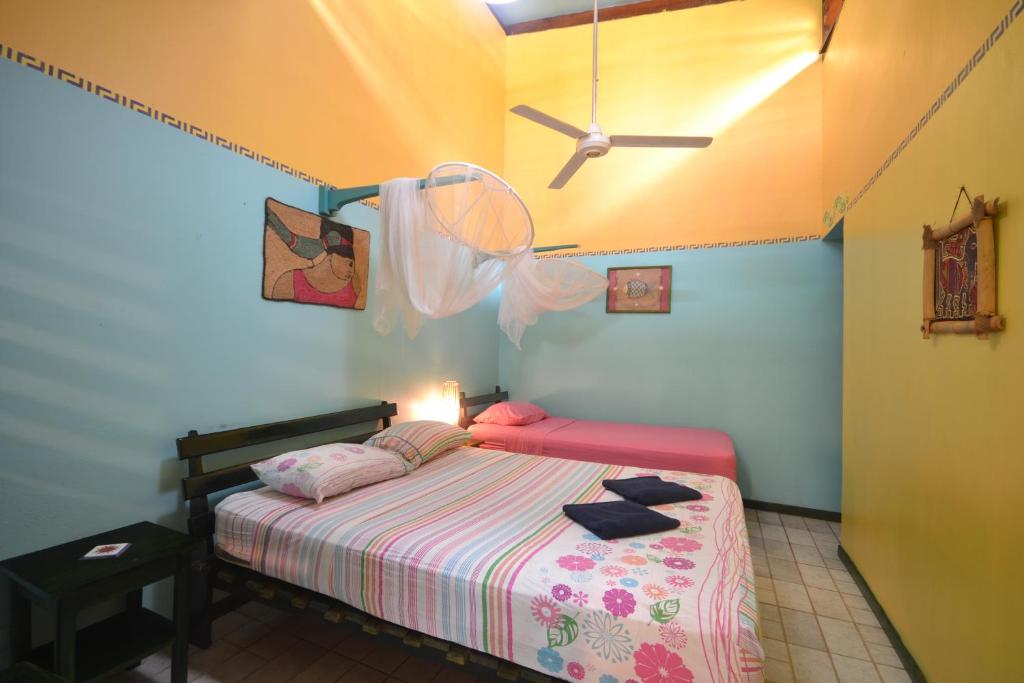 a bedroom with a bed and a ceiling fan at Cabinas Guarana in Puerto Viejo