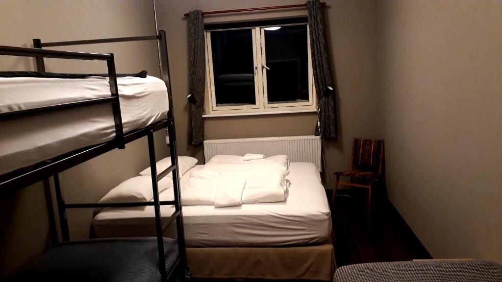 a room with two bunk beds and a window at Tehúsið Hostel in Egilsstadir