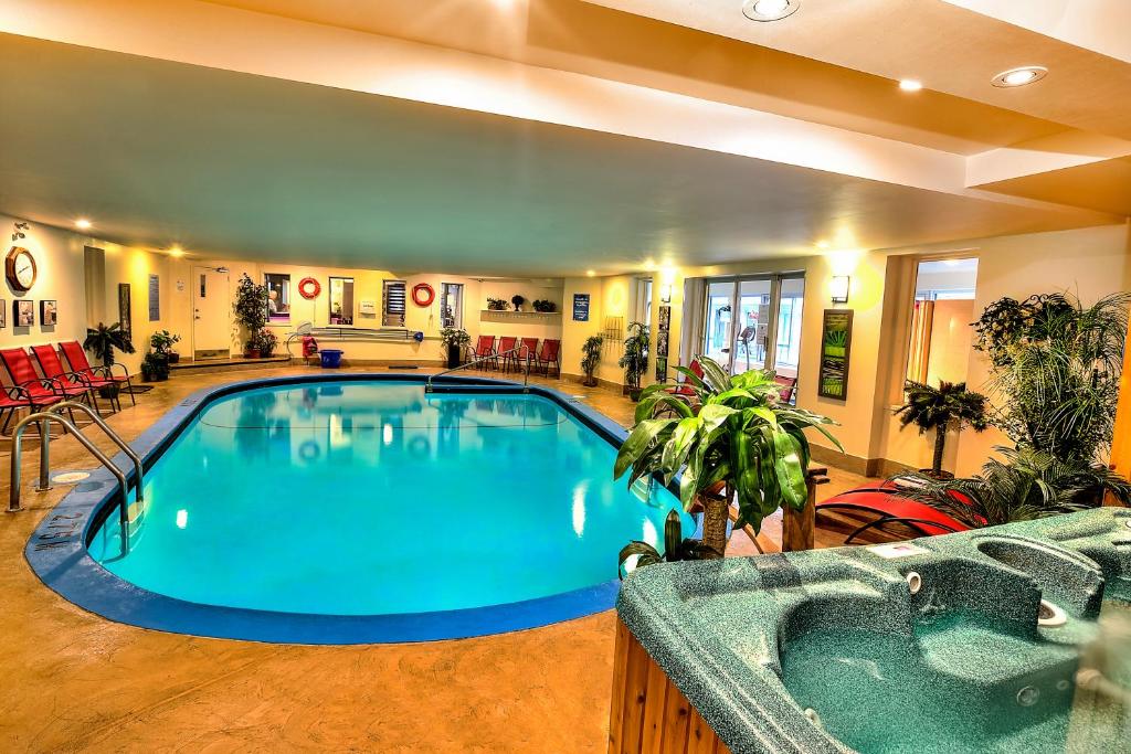 a large swimming pool in a large room with a hot tub at Hotel et Motel Le Chateauguay in Quebec City