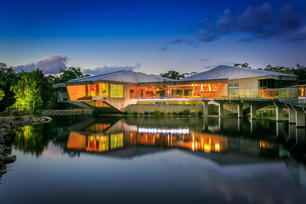 a house on a bridge over a body of water at Alkira Daintree Rainforest Luxury Holiday Home with Private Beach in Cape Tribulation