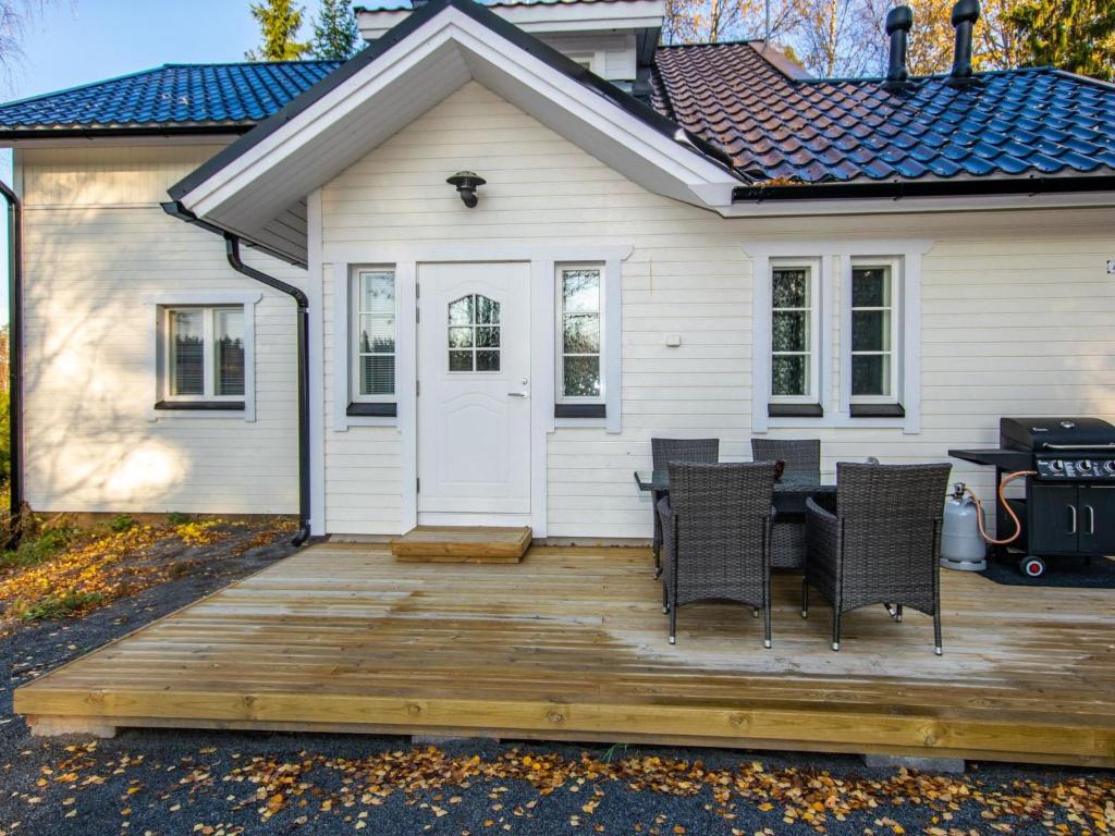 a deck with chairs and a table in front of a house at Holiday Home Hovimäki by Interhome in Vähäsalmi