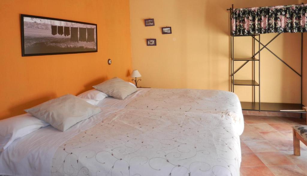 a bedroom with a large white bed in a room at Casa Rebollares I in Piedralaves