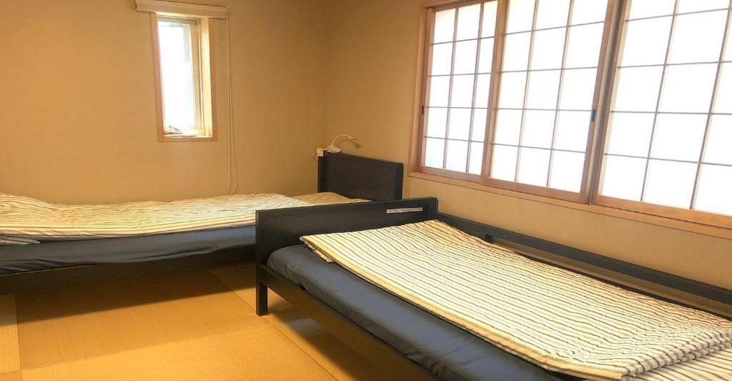 a room with two beds and two windows at 3-25-2 Higashiogu - Apartment / Vacation STAY 8348 in Tokyo
