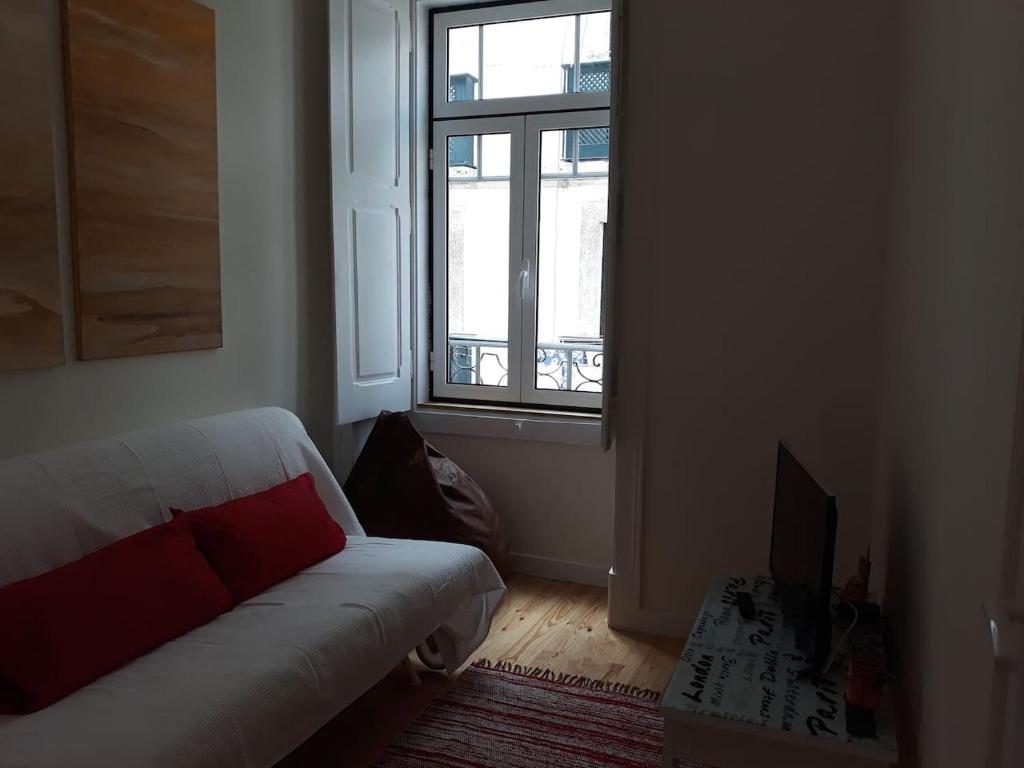 リスボンにあるLovely flat in Adamastorのリビングルーム(ソファ、窓付)