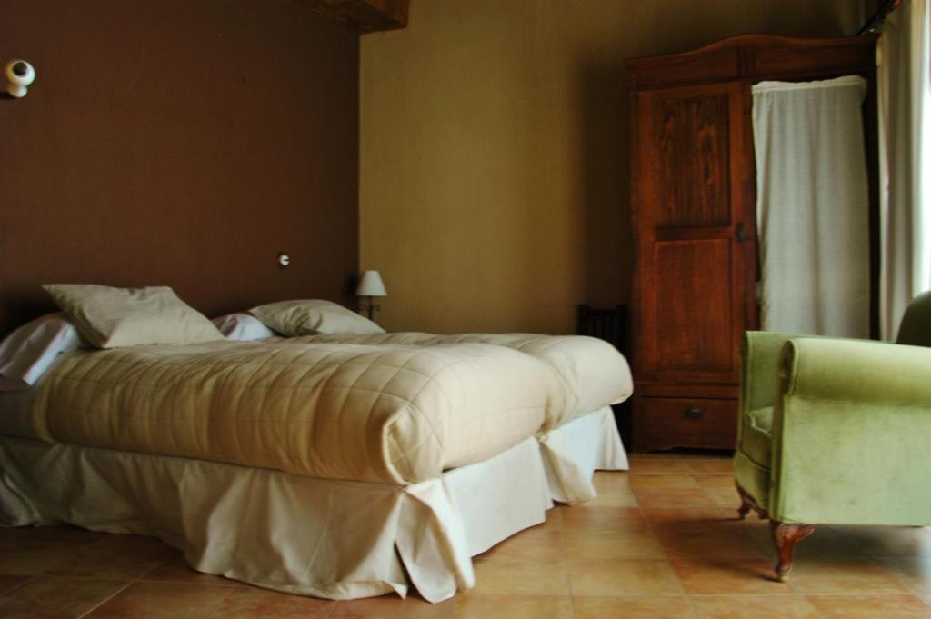 ピエドララベスにあるCasa Rebollares Iiのベッドルーム(大型ベッド1台、椅子付)