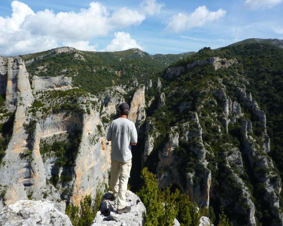 un hombre parado en una roca mirando hacia las montañas en Casa Paco, en Santa María Lanuez