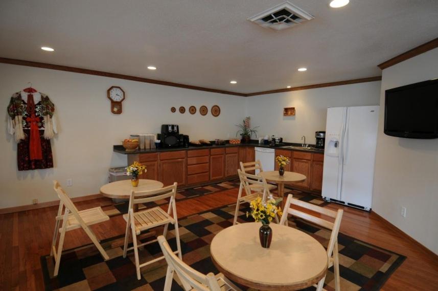 a kitchen with two tables and chairs and a refrigerator at Legacy Inn in Price