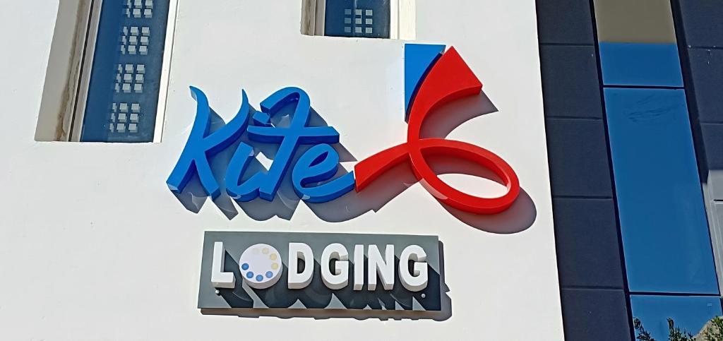 a sign for a store with a red pair of scissors at Kite Lodging in Hurghada
