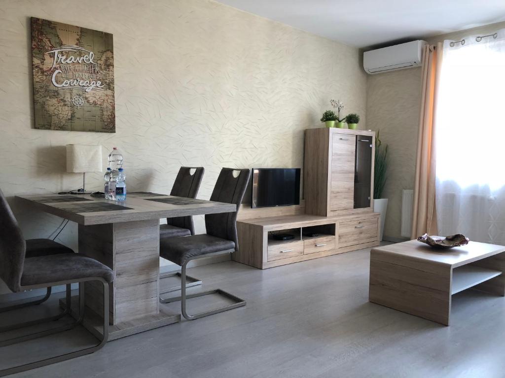 a living room with a table and chairs and a television at Aden Apartment free parking in Budapest