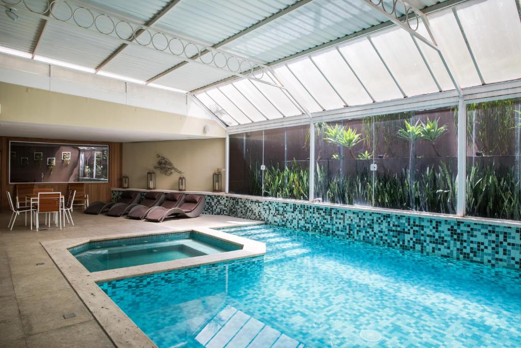 a swimming pool in a house with a large window at Hotel Heritage in Sao Paulo