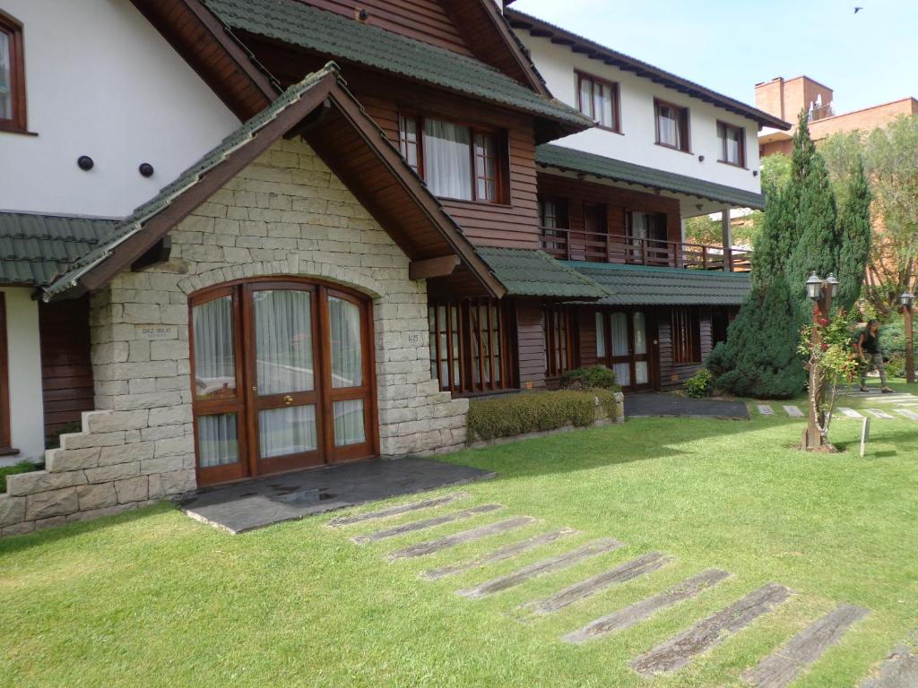 una casa con un patio de hierba delante de ella en Complejo Frente al Golf, en Pinamar