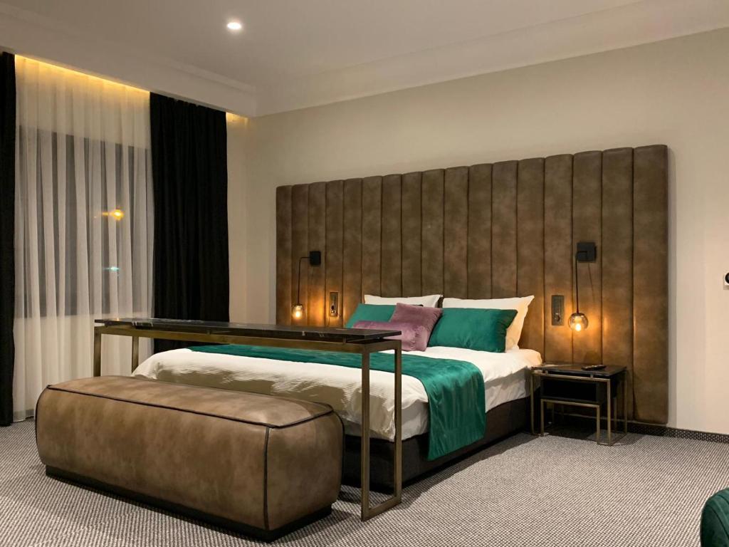um quarto com uma cama grande e uma grande cabeceira. em Hotel Rubis em Ferizaj
