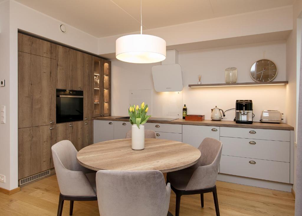 a kitchen with a wooden table and chairs in a kitchen at TP City Apartment - City Center in Tallinn