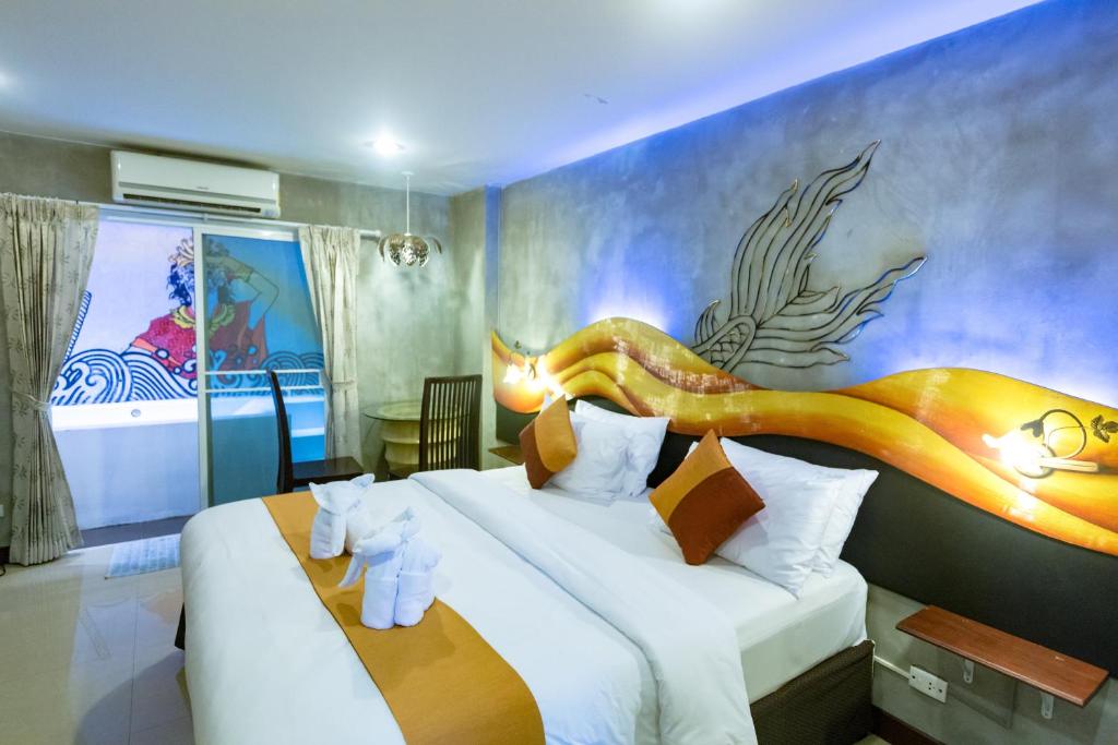 a hotel room with a bed with a dragon on the wall at Baan Kamala Fantasea Hotel in Kamala Beach