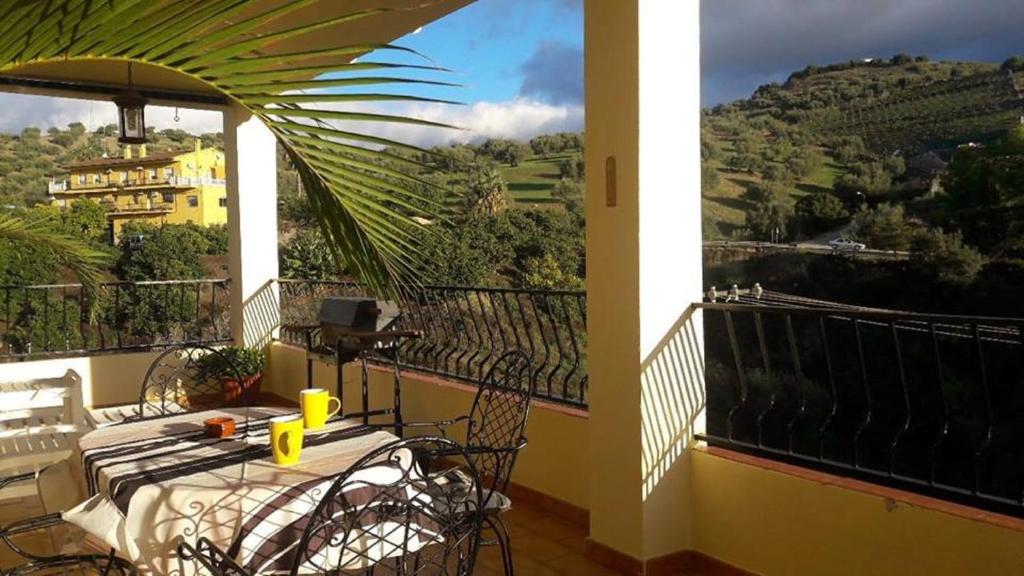 einen Tisch und Stühle auf einem Balkon mit Aussicht in der Unterkunft Apartamentos Vista La Maroma in Viñuela