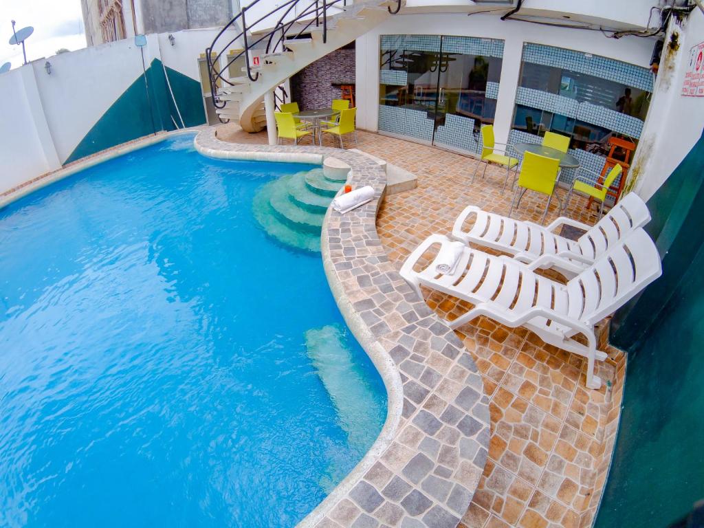 a swimming pool with lounge chairs and a slide at Hotel Jhor Bush in Pucallpa