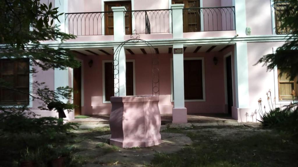un edificio rosa con un pilar delante suyo a marrachi en Villa Gesell