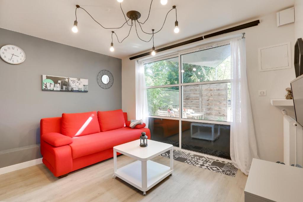 ein Wohnzimmer mit einem roten Sofa und einem Fenster in der Unterkunft Appart-hôtel64 Bayonne in Bayonne