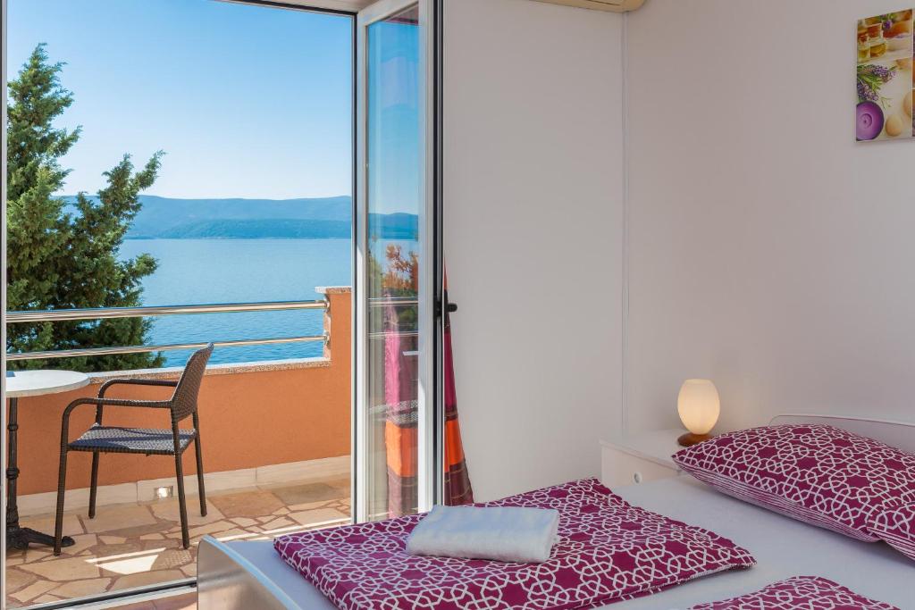 um quarto com uma cama e uma varanda com vista em Adriatic Blue Apartments em Lokva Rogoznica