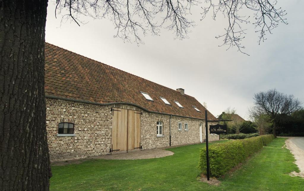 een groot bakstenen gebouw met een houten garage bij B&B In de velden in Bocholt