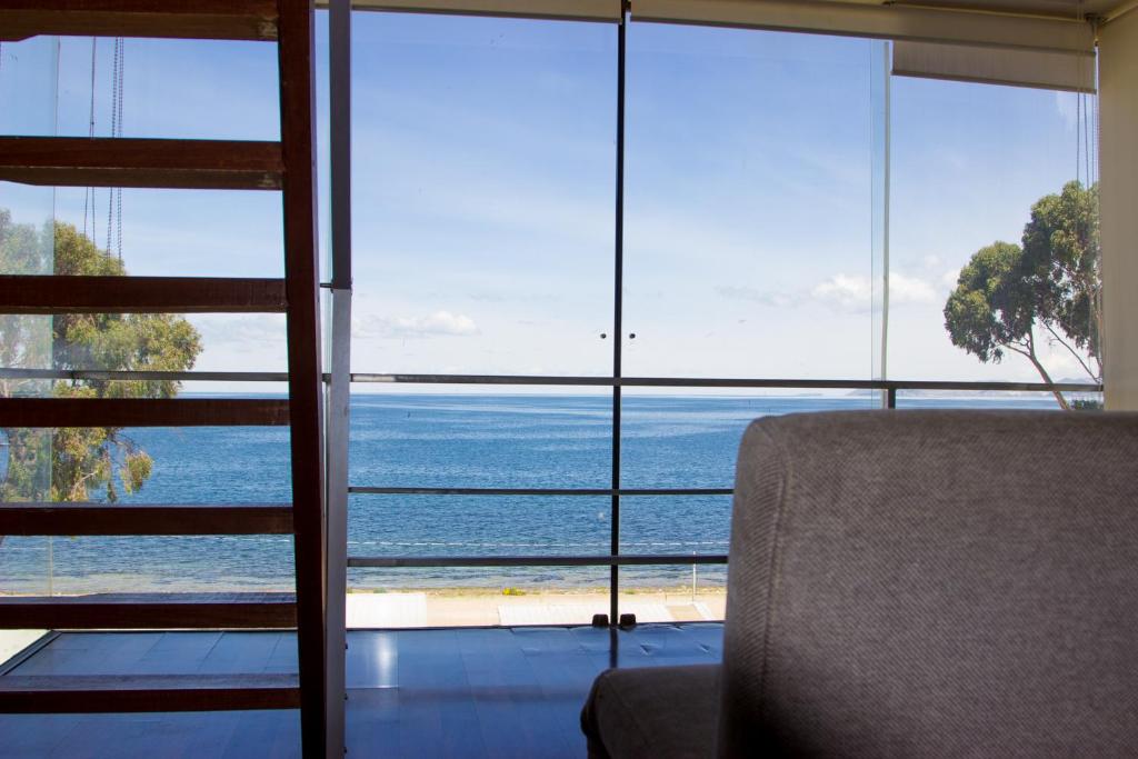 Habitación con silla y vistas al océano en Hotel Onkel Inn Torres de Copacabana, en Copacabana