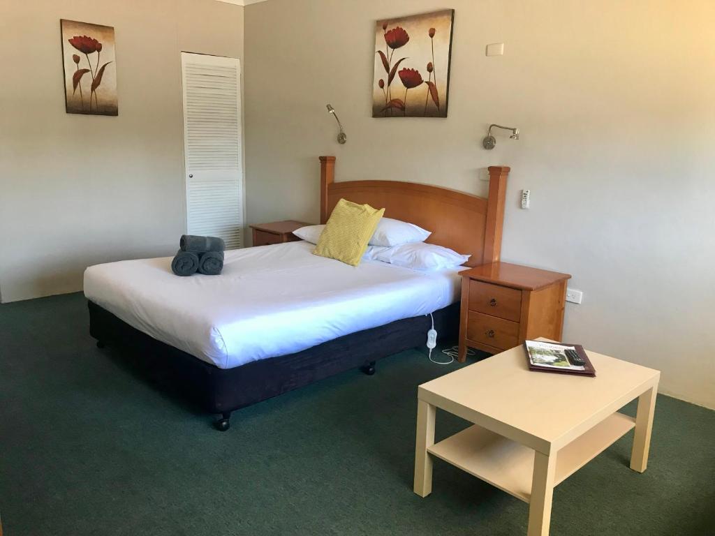a hotel room with a bed and a table at Motel Wellington Wodonga in Wodonga