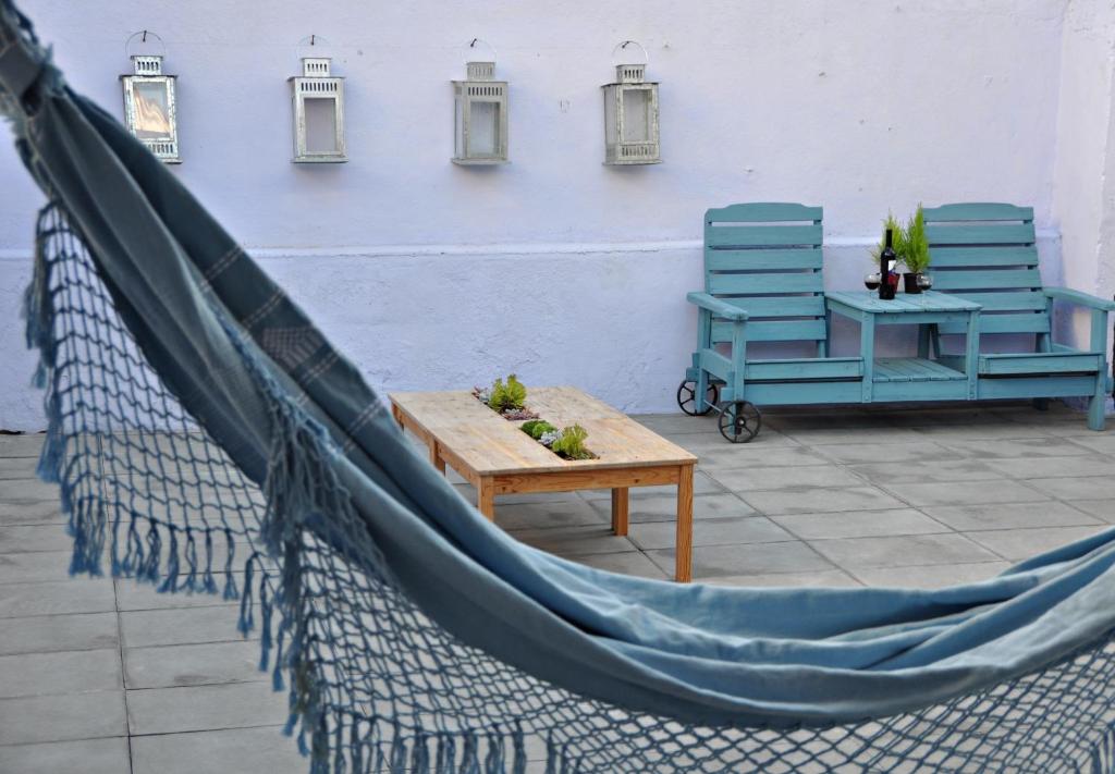 twee blauwe stoelen en een hangmat op een patio bij Aloha Beach House H in Cascais