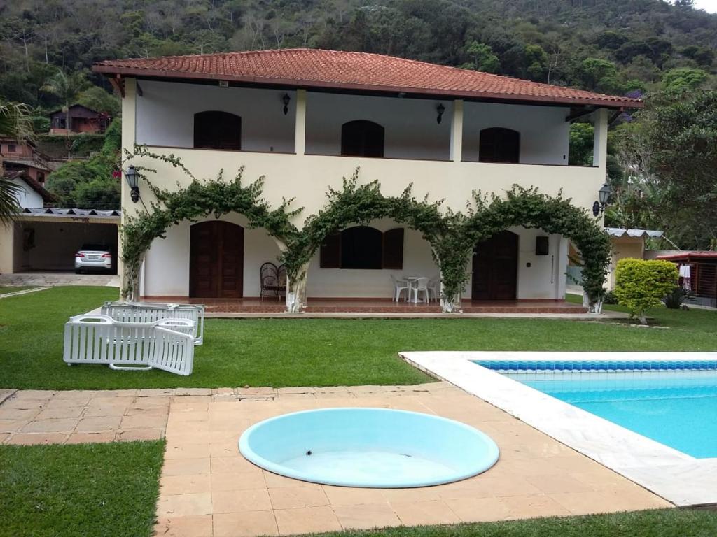 a villa with a swimming pool and a house at Casa Aconchegante - Circuito Teresópolis Friburgo in Teresópolis