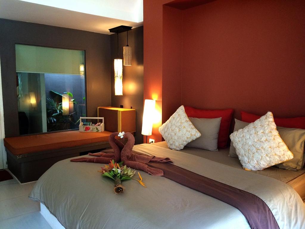 a bedroom with a bed with a flower arrangement on it at Phayam Cottage Resort in Ko Phayam