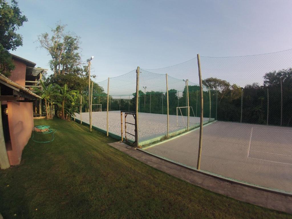 a tennis court with a net on a tennis court at Bangalô no alto da colina no Villas do Pratagy - Maceió in Maceió
