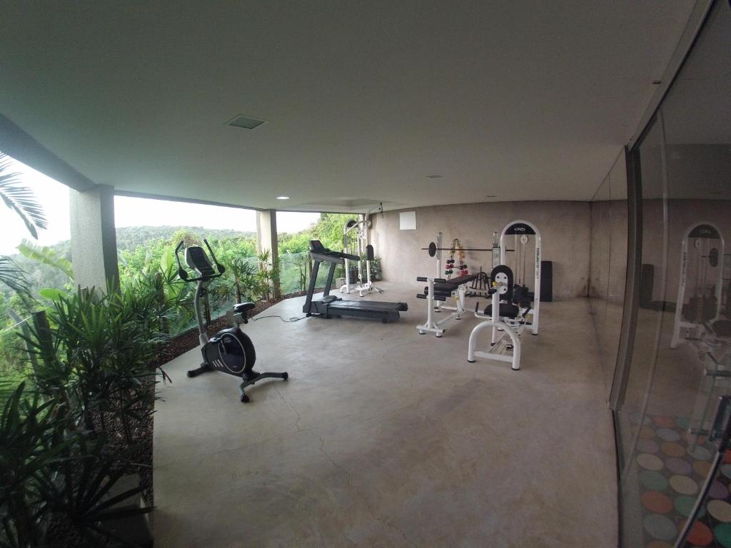 a gym with treadmills and exercise equipment in a building at Bangalô no alto da colina no Villas do Pratagy - Maceió in Maceió