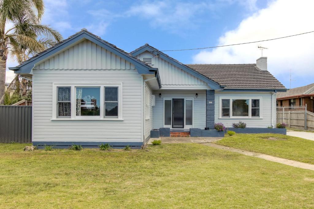 a white house with a yard at Seashells - Central Family Getaway in Lakes Entrance