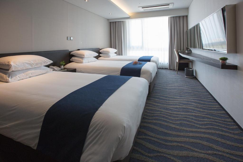 Postel nebo postele na pokoji v ubytování Gloucester Hotel Jeju